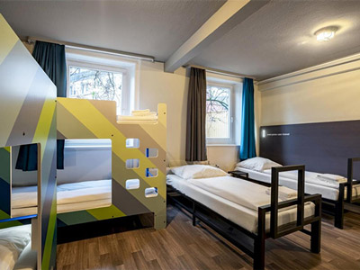 Two blue bunk beds on each side of the wall, with a long table and chairs in the middle of the room - Rank #6