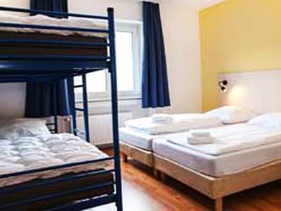 A room containing twin beds and bunk beds