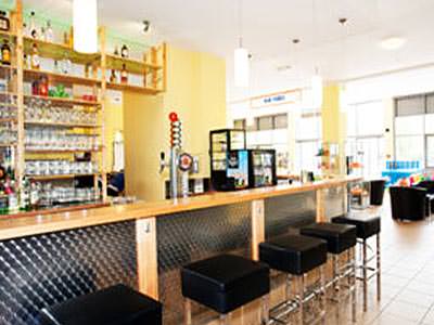 The bar area with bar stools and spirits lining the wall in A&O Laim