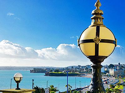 A street lamp to a backdrop of the blue sky and sea