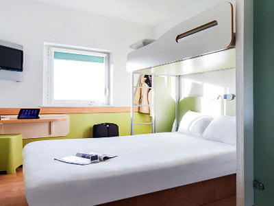 A white double bunk bed in a hotel room 