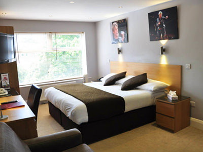 Image of a double room at Hotel Celebrity, with a double bed and desk at the foot of the bed 