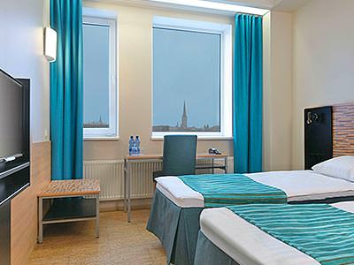 A guest room with two twin beds and blue highlights