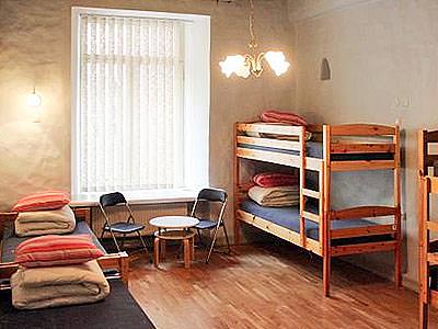 A large room with twin beds, bunk beds and a table and chairs