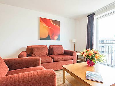 Two red sofas around a coffee table, in an apartment
