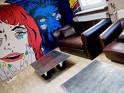 A seating area and wall mural at Corner Hostel