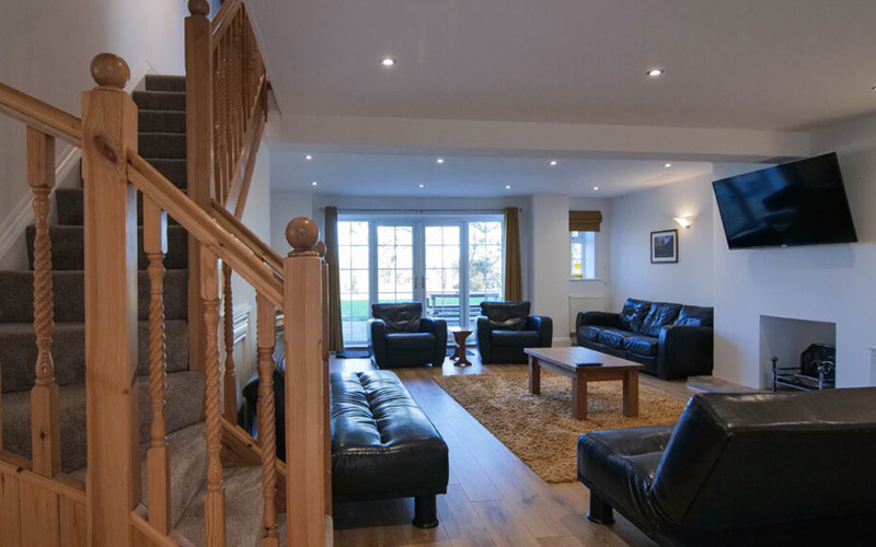 The living room is very spacious with sofas and a wall mounted TV 
