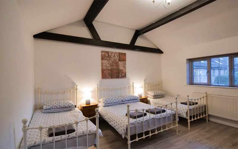 Bedroom with two single beds and a double bed 