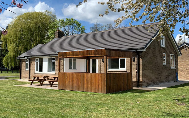 The exterior of the back of the property with hot tub and bench seating 