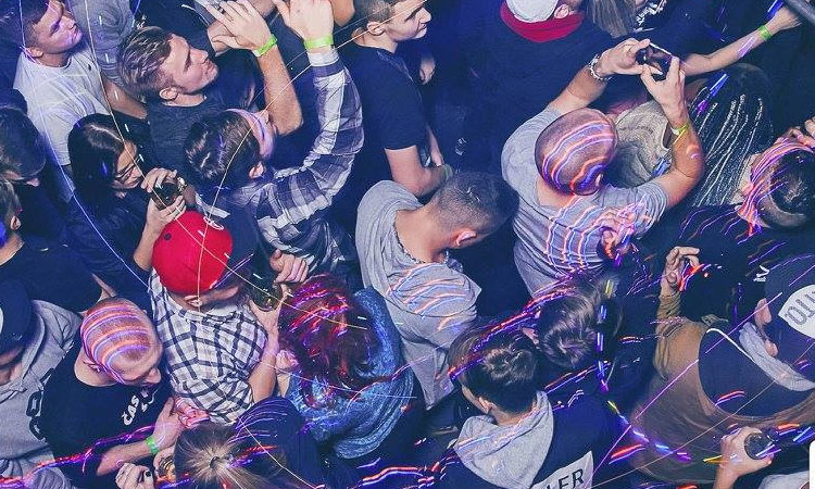 A bird's eye view of some lads dancing with lasers above them