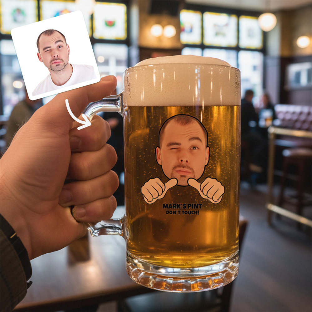 A custom stein that has been personalised with a man's face that have cartoon thumbs pointing towards him and custom text reading Mark's Pint, Don't Touch! with a pub background 