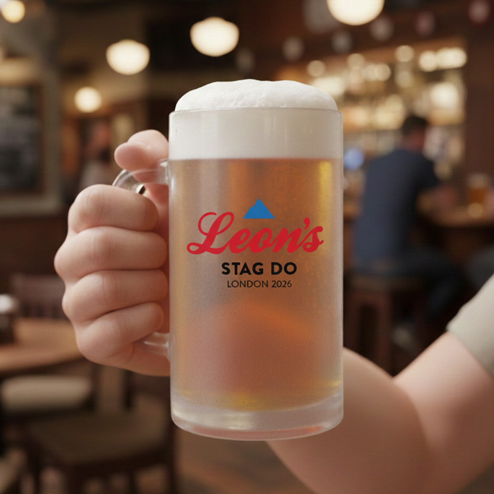 A Coors themed frosted glass stein boasting a mountain logo that has the custom text Leon's Stag Do London 2026 with a pub background 
