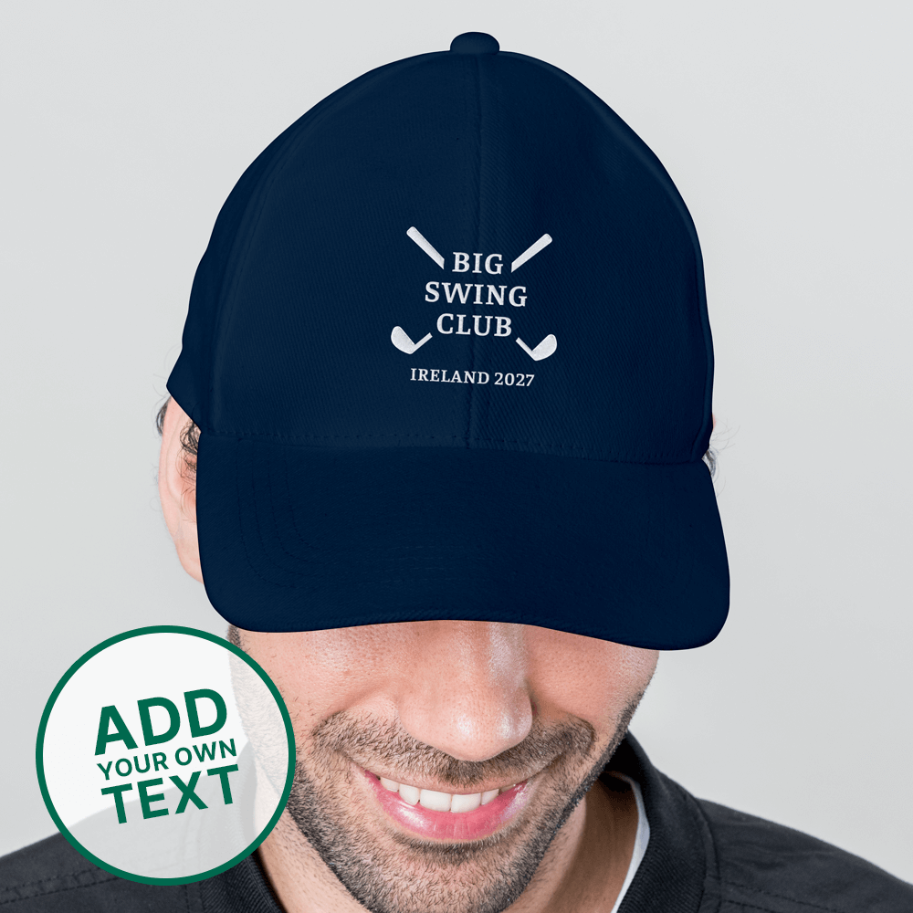 A male model wearing a blue golfing cap with an embroidered logo reading Big Swing Club with a design of two golf clubs crossed over each other in an X shape with Ireland 2027 underneath it