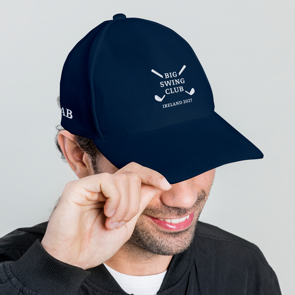 A side view of a male model wearing a blue golfing cap with an embroidered logo reading Big Swing Club with a design of two golf clubs crossed over each other in an X shape with Ireland 2027 underneath it