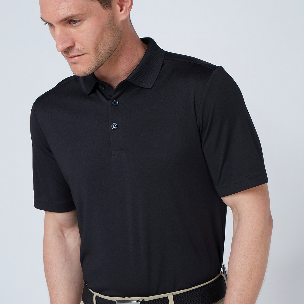 A male model wearing a black Callaway - Tournament polo shirt 