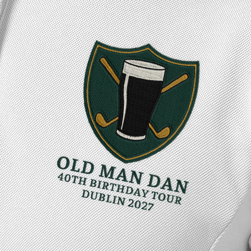 Close up shot of a male model wearing a blue golfing shirt with an embroidered crest that has a pint of beer in front of golf clubs that cross over each other in an X shape with custom text reading Old Man Dan, 40th Birthday Tour, Dublin 2027