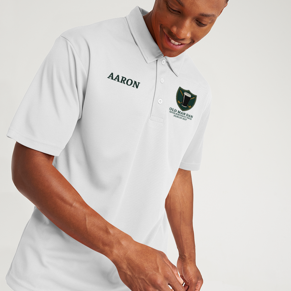 a white golfing shirt with an embroidered crest that has a pint of beer in front of golf clubs that cross over each other in an X shape with custom text reading Old Man Dan, 40th Birthday Tour, Dublin 2027