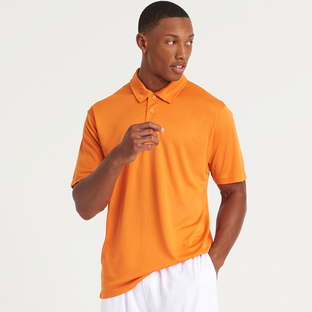 A male model wearing an orange AWDis Just Cool Cool Polo 