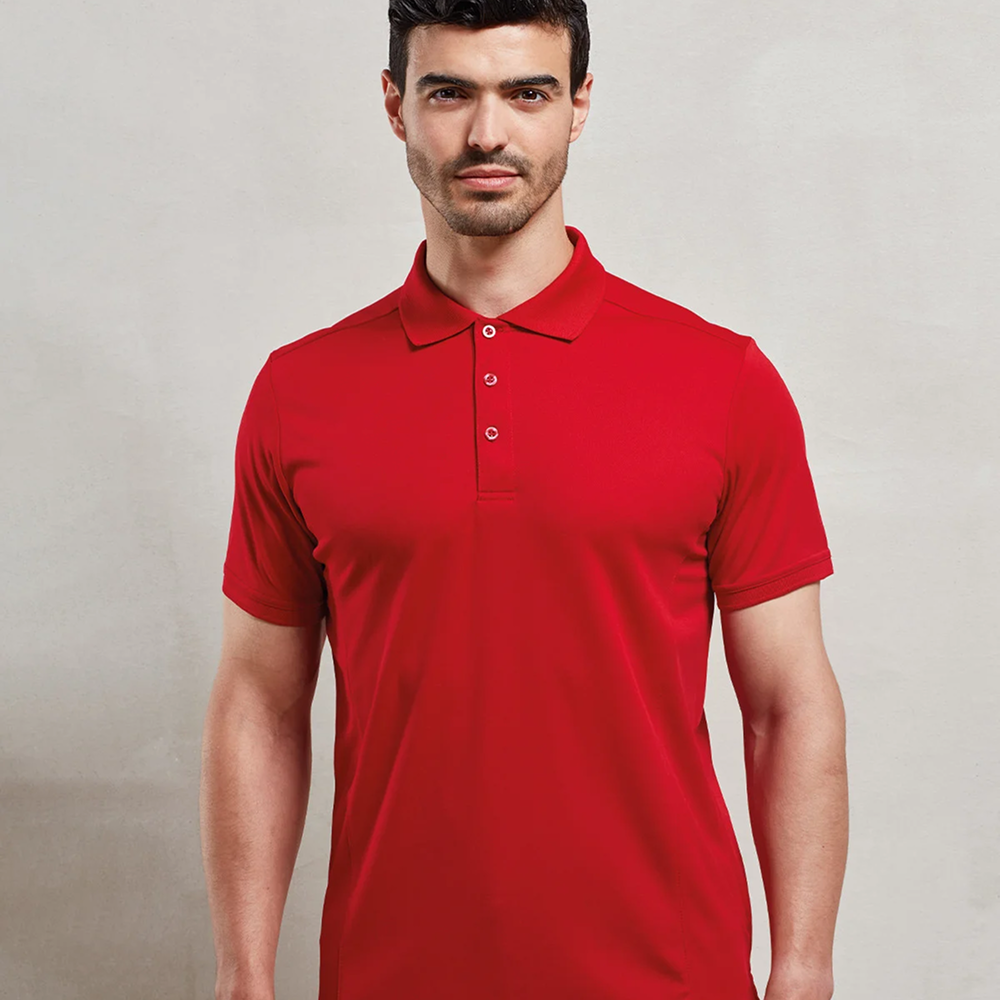 A male model wearing a red Premier Coolchecker Pique Polo 
