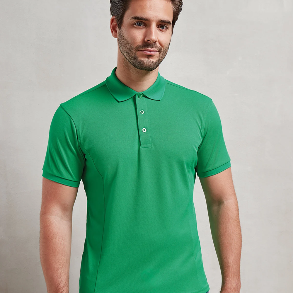 A male model wearing a green Premier Coolchecker plus pique polo 