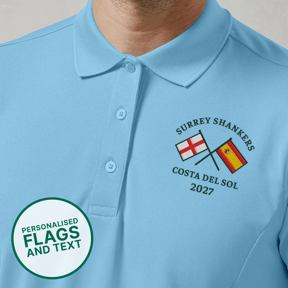 A blue custom golf polo with a multi flags design that is an England flag crossed over a Spain flag with the text Surrey Shankers, Costa Del Sol, 2027 