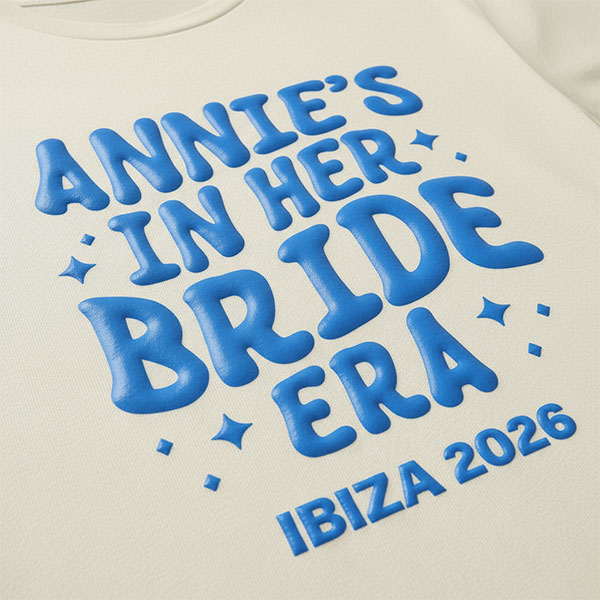 A white hen do shirt with custom blue 'puff print' bubble writing that reads Annie's in her Bride Era, York, 2026