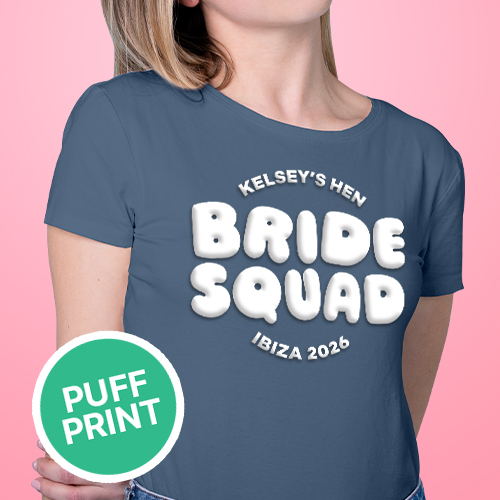  A female model wearing a blue hen do t shirt with custom white 'puff print' bubble writing that reads Kelsey's Hen, Bride Squad, Ibiza 2026 