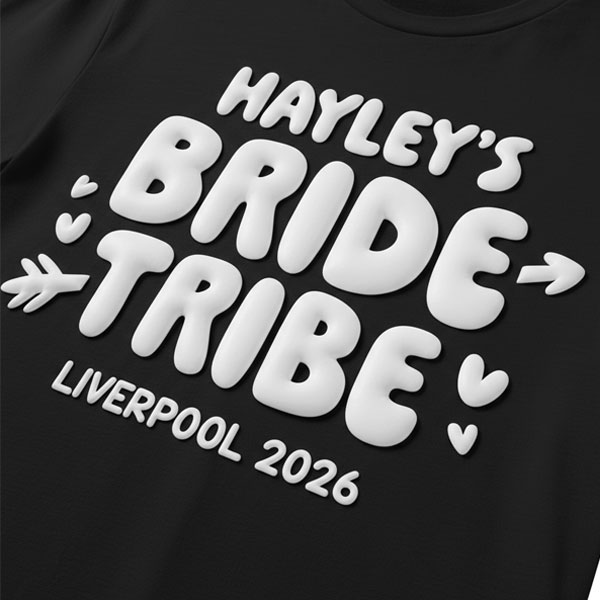 A black hen do t shirt with custom bubble writing that reads Hayley's Bride Tribe, Liverpool 2026