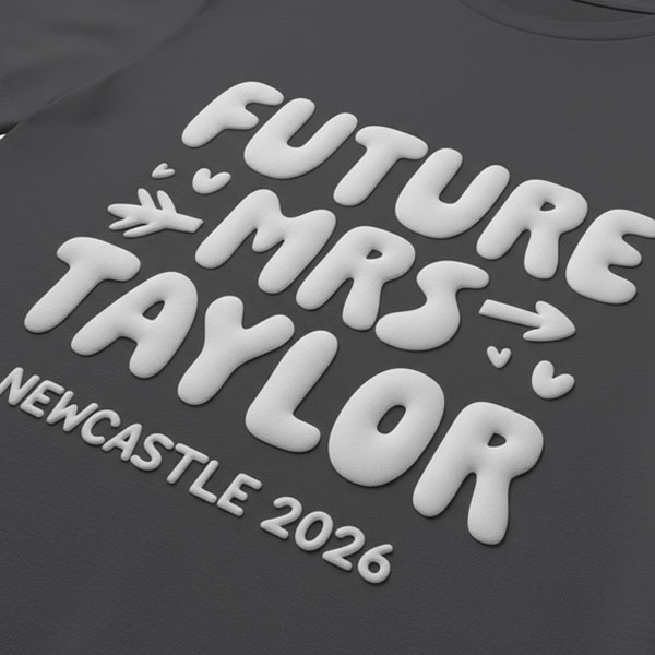 A black hen do shirt with custom metallic white 'puff print' bubble writing that reads Future Mrs Taylor, Newcastle 2026