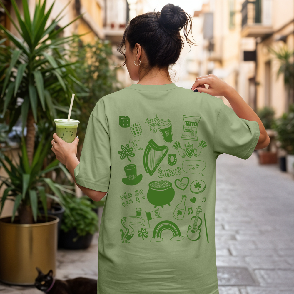 The back of a green St Paddy's themed hen do t-shirt that has various St Patrick themed doodles including a clover, a pot of gold, the Guinness harp and more.