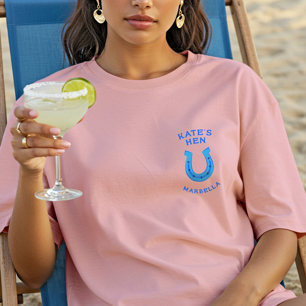 The front of a Pink Pony Club themed hen do shirt which has a horseshoe on the front with the custom text Kate's Hen Marbella