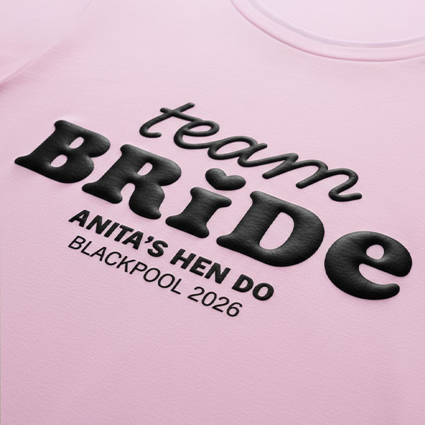 A pink hen do shirt with custom black 'puff print' bubble writing that reads Team Bride, Anita's Hen Do, Blackpool 2026
