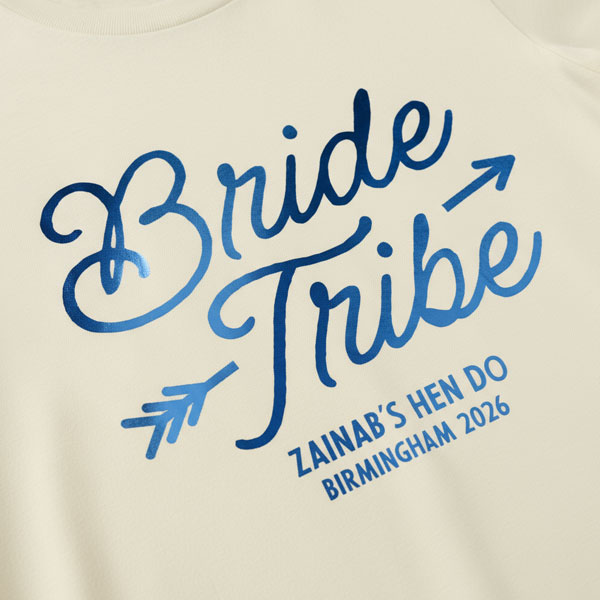 A white hen do shirt with custom shiny foil blue coloured text that reads Bride Tribe, Zainab's Hen Do, Birmingham 2026