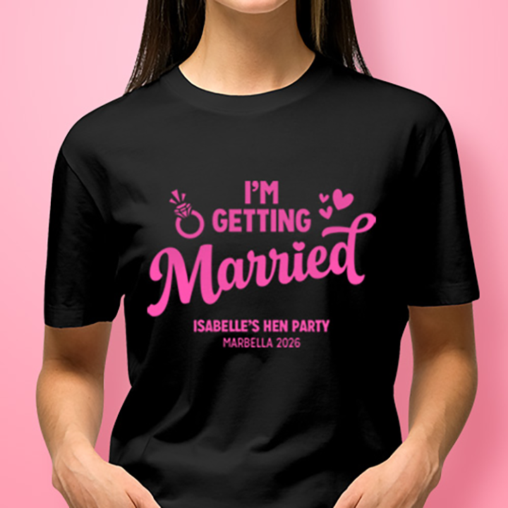 A woman wearing a black custom hen do t shirt that reads I'm getting married, Isabelle's Hen Party, Marbella 2026
