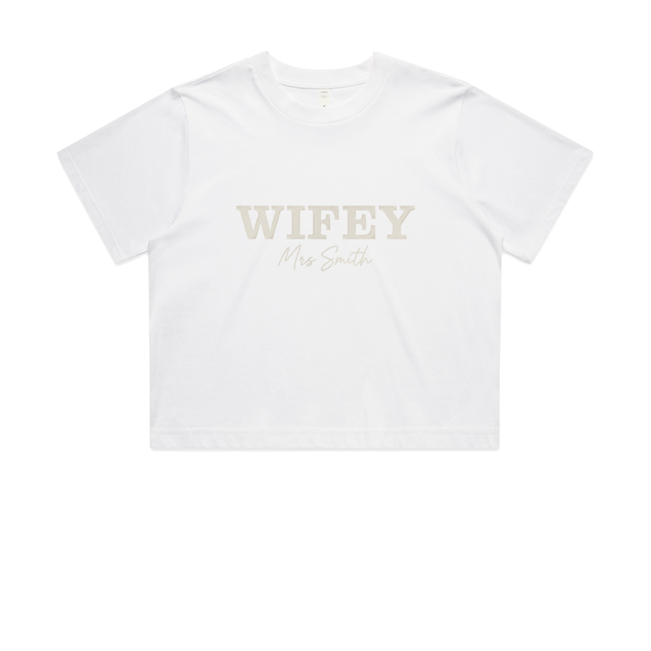 A honeymoon crop t shirt with WIFEY embroidered in statement text and Mrs Smith embroidered in cursive font 