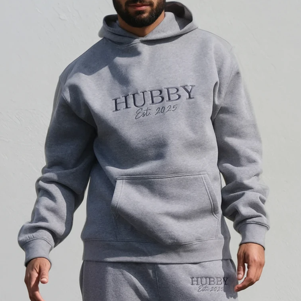 A male model wearing luxe honeymoon hoodie that is embroidered with HUBBY