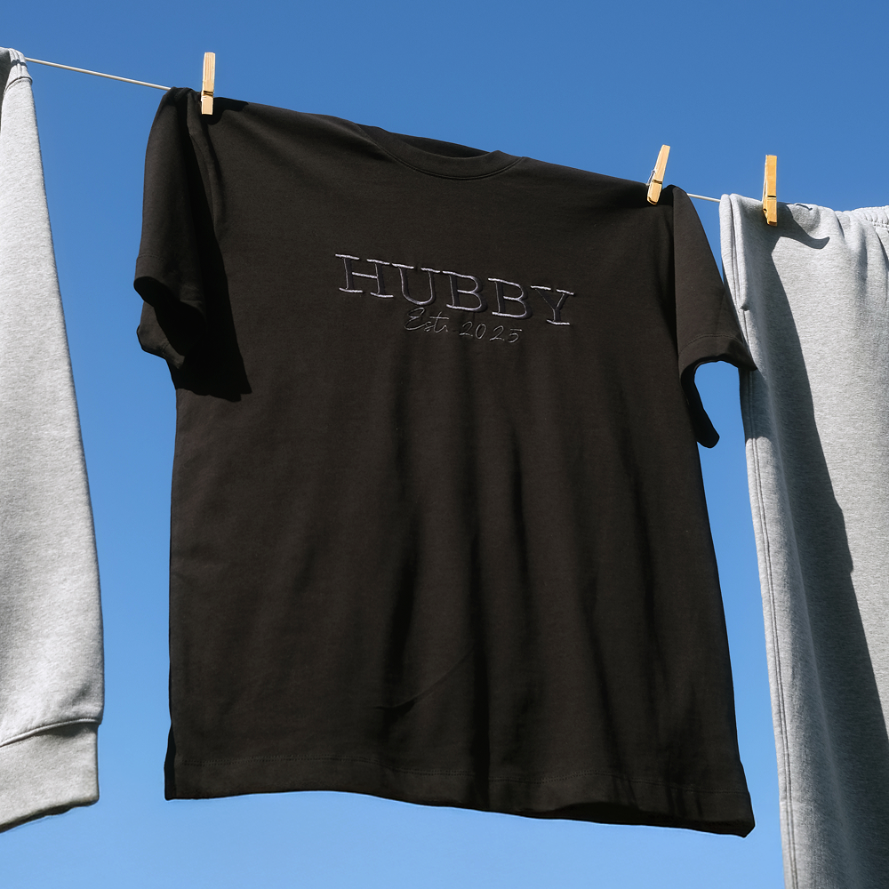 A luxe black honeymoon shirt that has HUBBY est 2025 embroidered on it