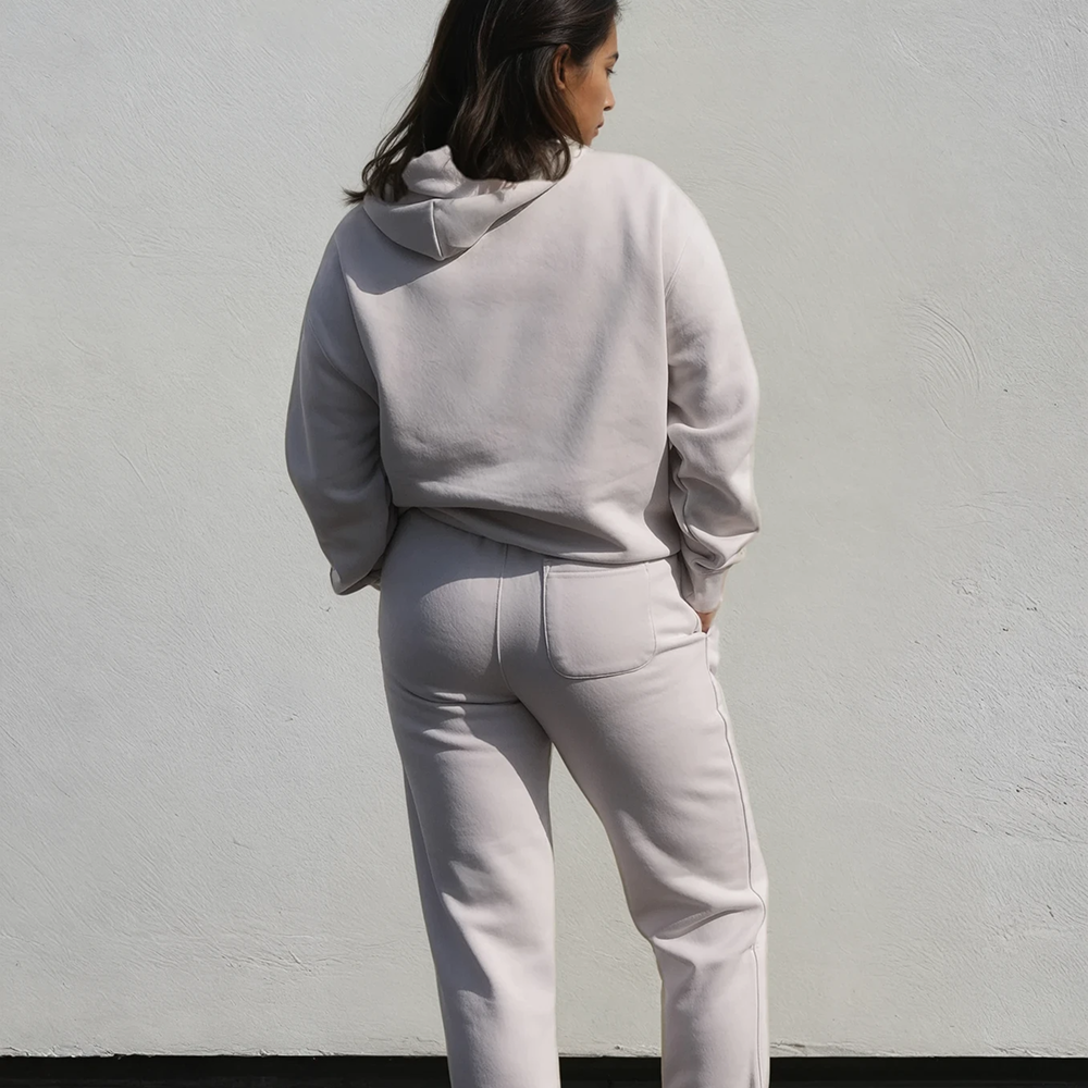 A shot of a model wearing a luxurious looking hoodie and matching joggers taken from behind