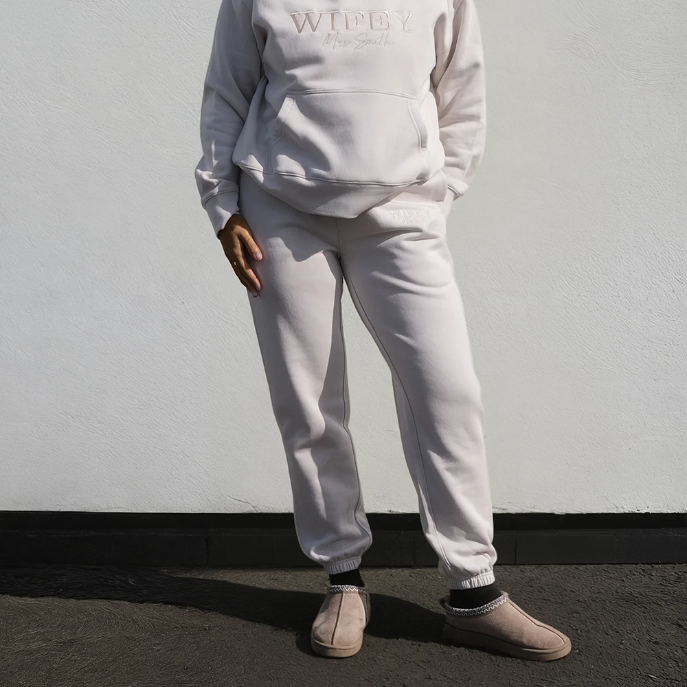 A model wearing a matching hoodie and joggers that have WIFEY embroidered on them 
