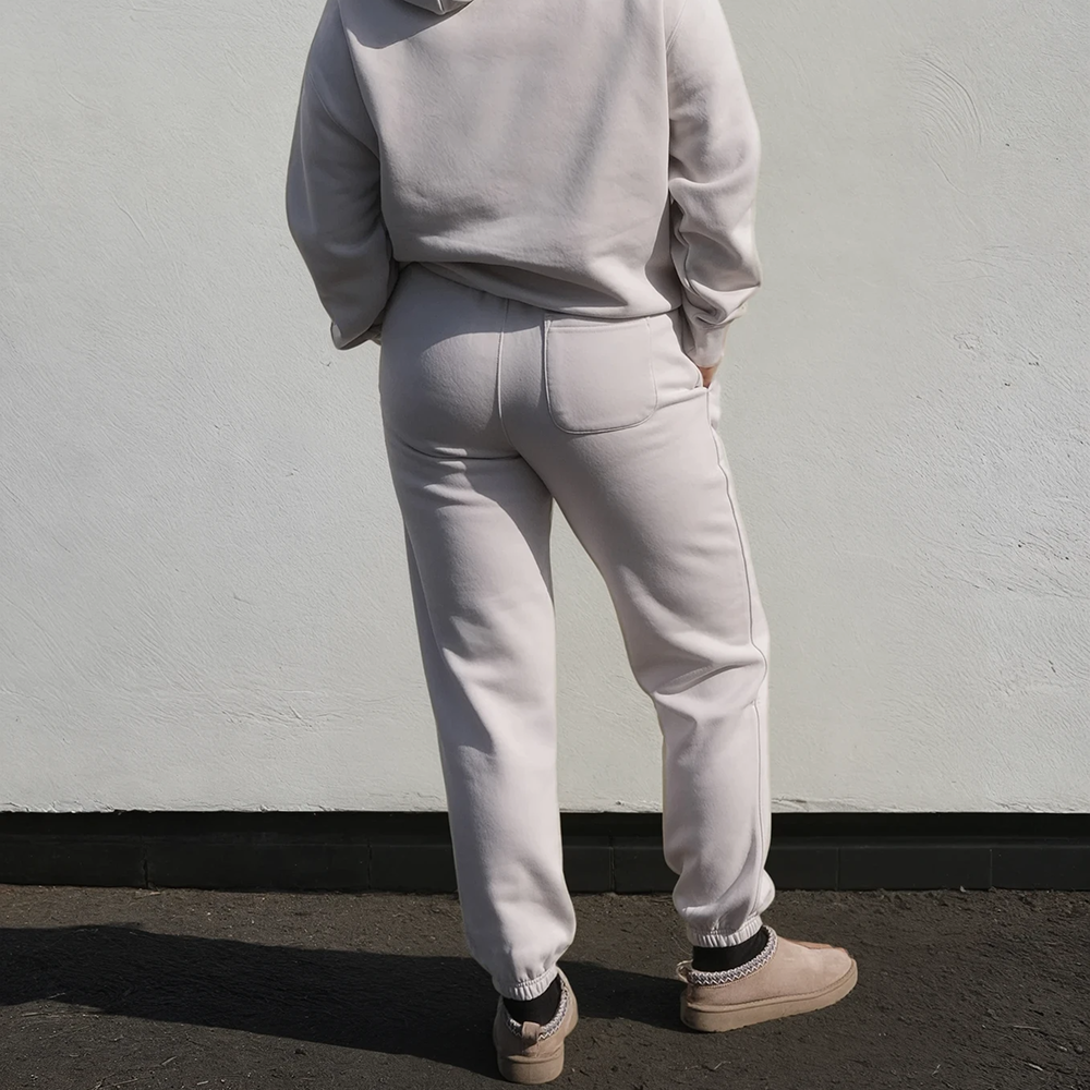 A back view of a model wearing a matching bone coloured honeymoon hoodie and joggers