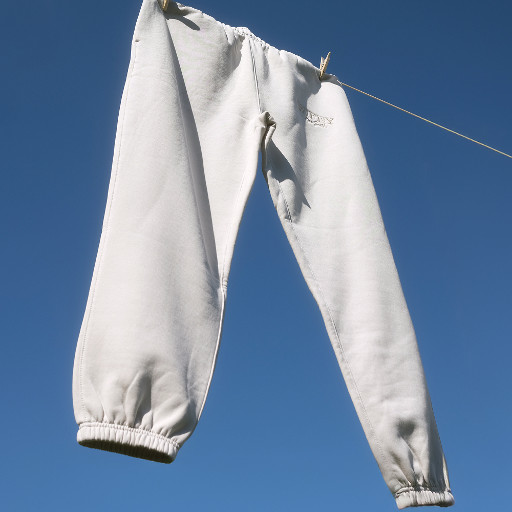 A pair of honeymoon joggers that have WIFEY embroidered on them hanging on a washing line