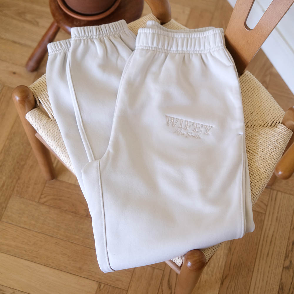 A pair of luxurious bone coloured honeymoon joggers folded up on a chair