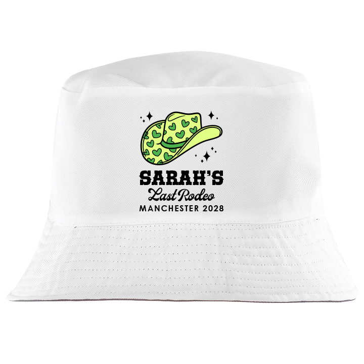 A custom hen do bucket hat which is white coloured with a design of a green cowgirl hat with the custom text Sarah's Last Rodeo Manchester 2028