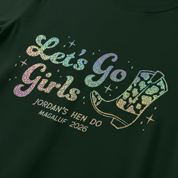 A black hen do shirt with custom shiny foil rainbow writing that has a cowboy boot on it and reads Let's Go Girls, Jordan's Hen Do Magaluf 2026