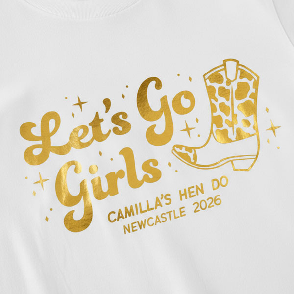 A white hen do shirt with custom shiny foil gold writing that has a cowboy boot on it and reads Let's Go Girls, Camilla's Hen Do Newcastle 2026