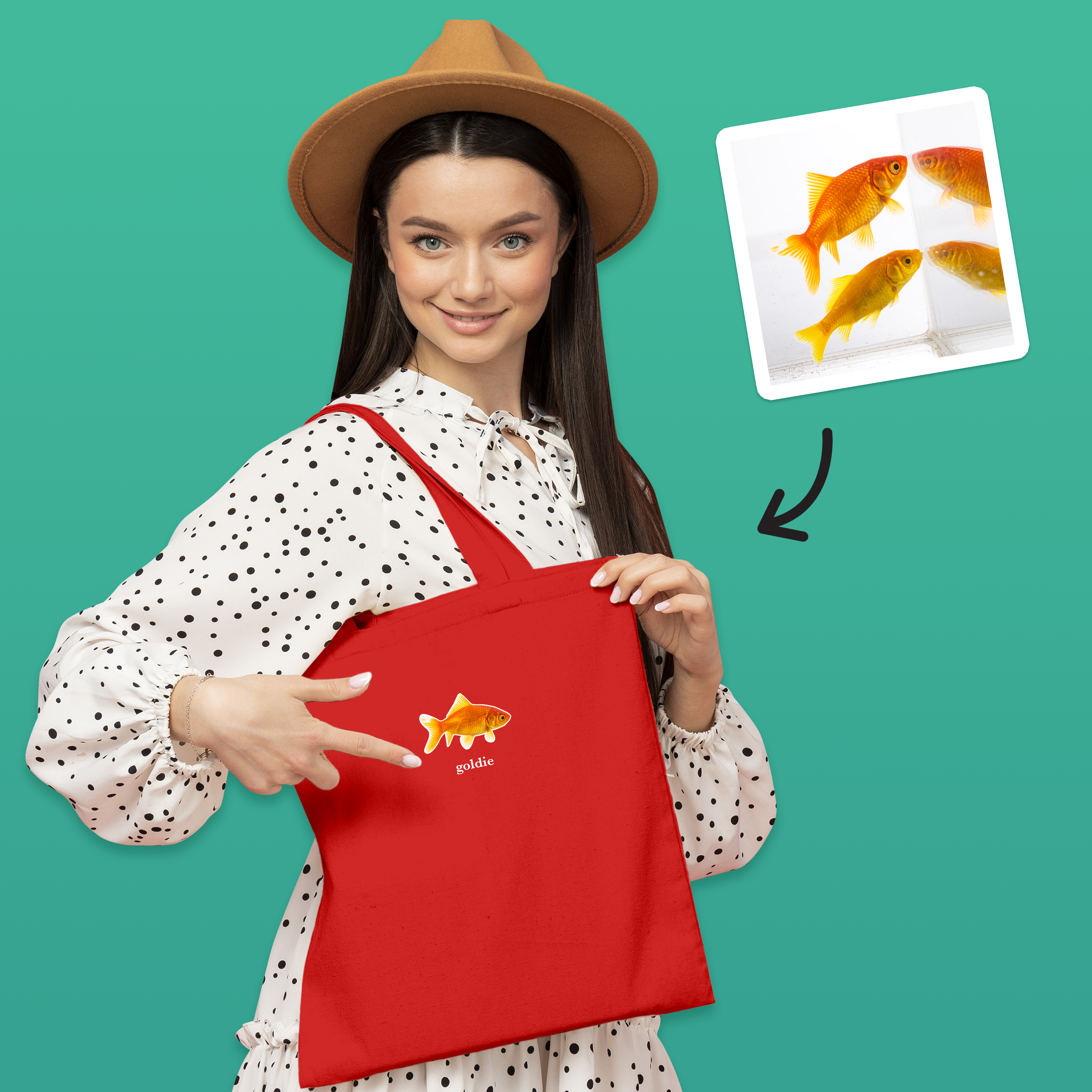 A female model modelling a blue tote bag that can be customised with the face of a pet and up to two lines of custom text, it has a fish on it and reads goldie underneath it