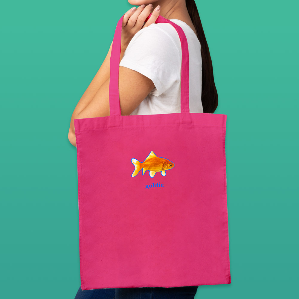 A female model holding a pink tote bag that can be customised with the face of a pet and up to two lines of custom text