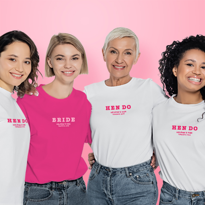 Four women, one is wearing a pink hen do t shirt that reads Bride in a subtle text, the other three women are wearing white hen do t shirts that read Hen Do in a subtle text