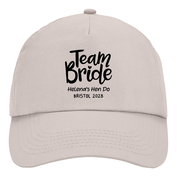 A sand coloured custom hen do cap reading Team Bride Helena's Hen Do Bristol 2028 in a black font