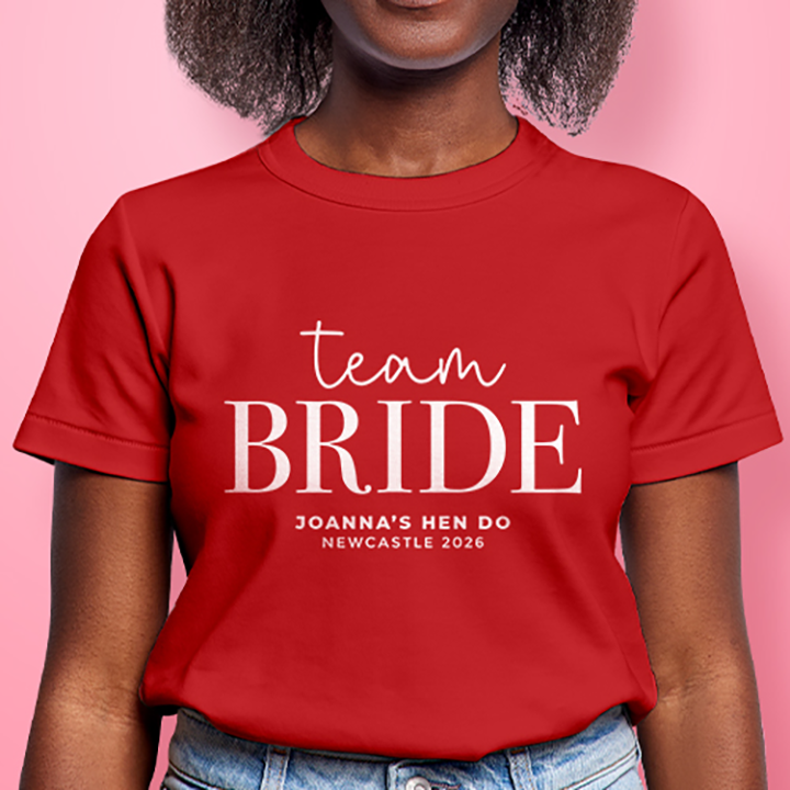 A female model wearing a red custom hen do t shirt with editable text that reads Team Bride, Joanna's Hen Do, Newcastle 2026